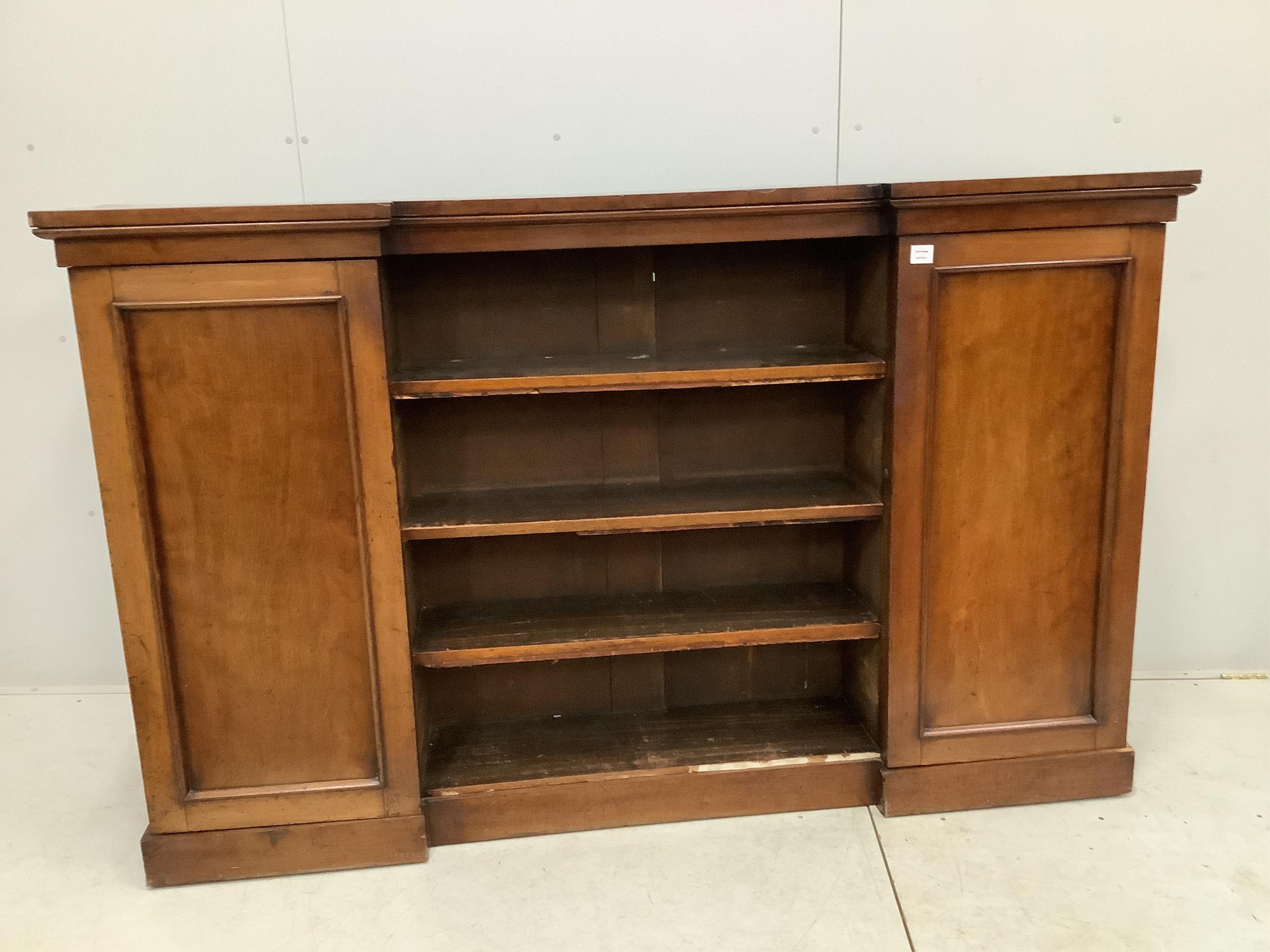 A Victorian mahogany inverted breakfront bookcase cupboard, width 198cm, depth 39cm, height 124cm. Condition - fair, one plinth foot corner split with lost veneer